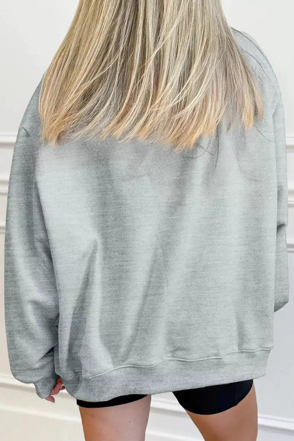 Gray oversized pullover sweatshirt; back view shows baggy fit, long sleeves, ribbed hem, soft knit fabric.