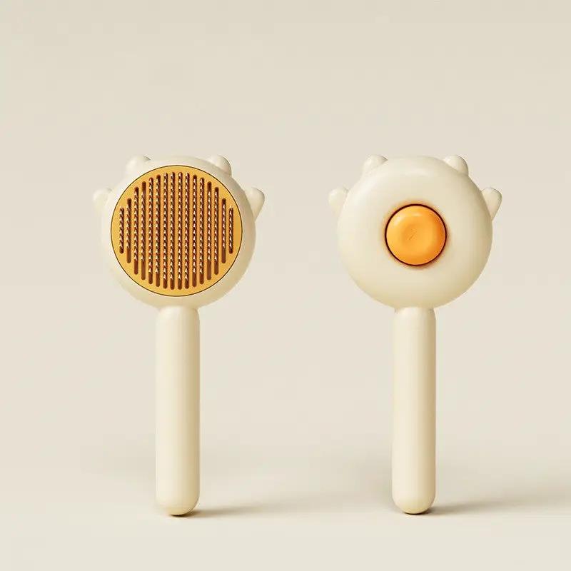 AdTec cat comb massage grooming brushes, 2-piece cream-colored set with orange button and bristled head