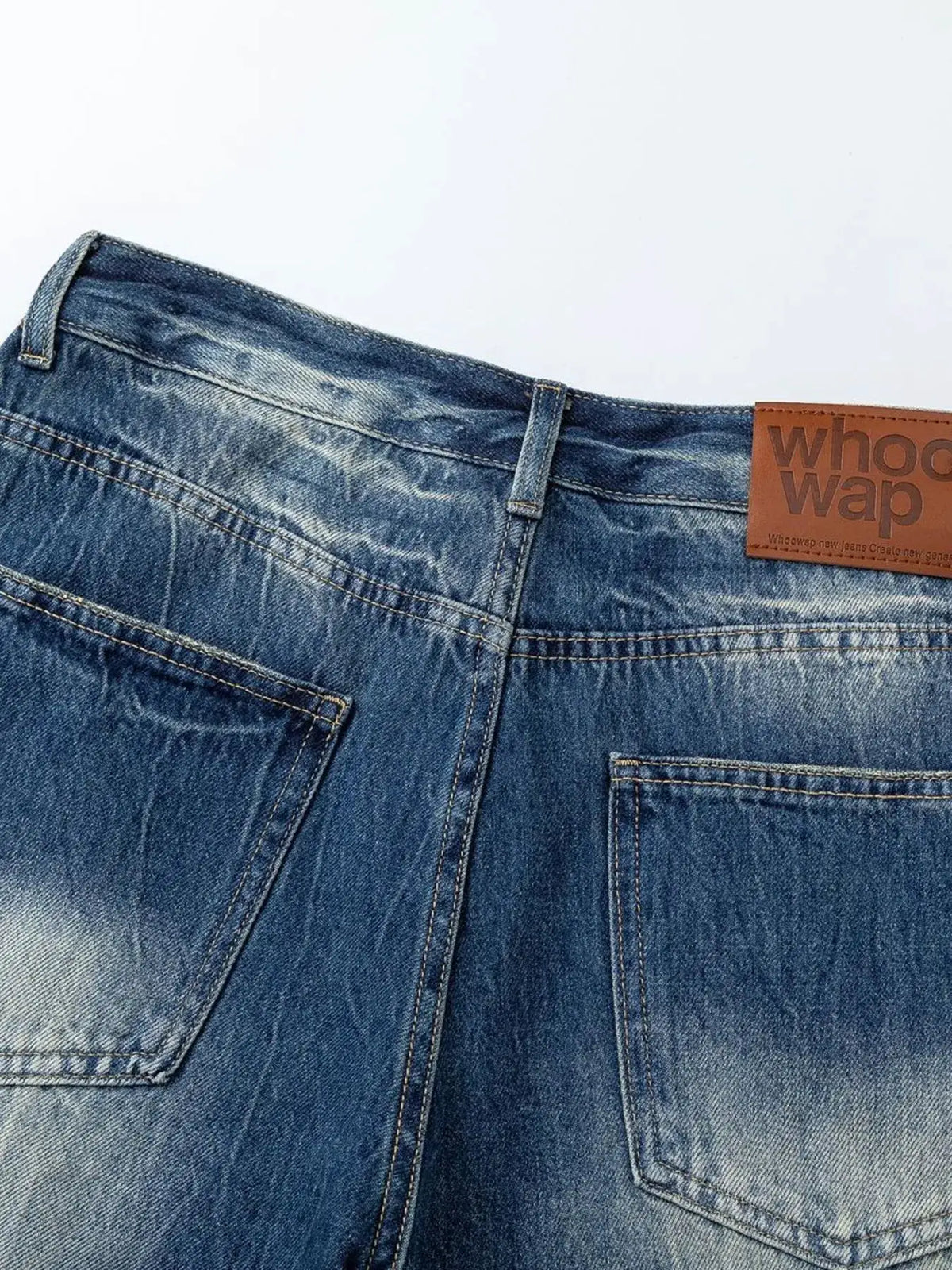 Men's washed blue denim shorts with back pockets and leather patch labeled Whoop
