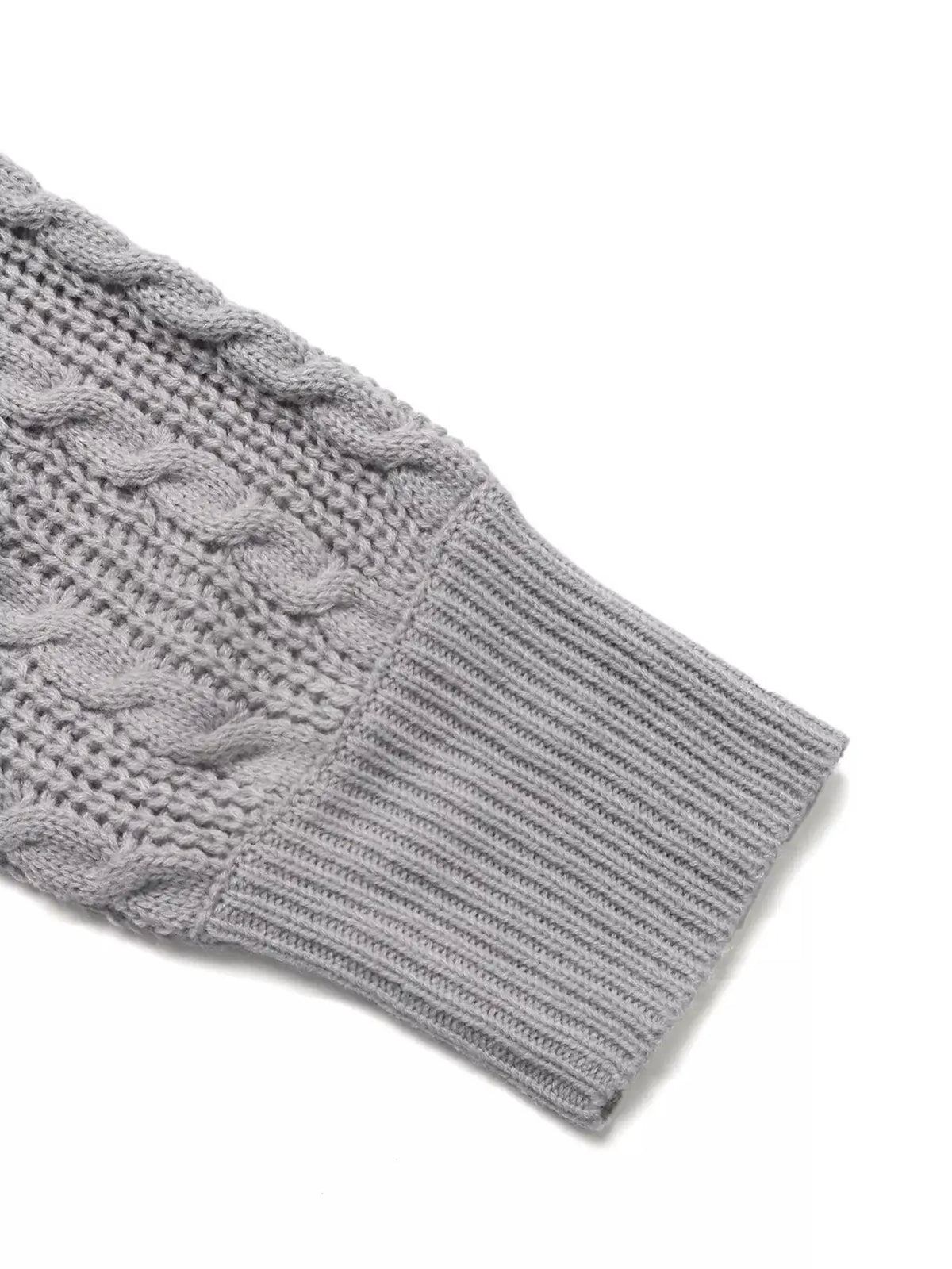 Cable-knit gray acrylic sweater close-up showing braided cables and ribbed cuff