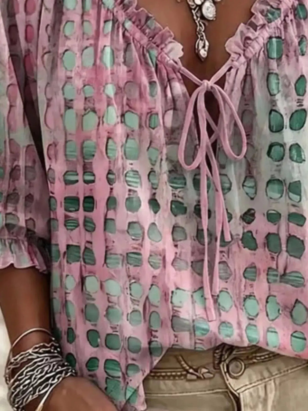 Plus-size pink tie-neck blouse with 3/4 sleeves and teal rounded-square pattern.