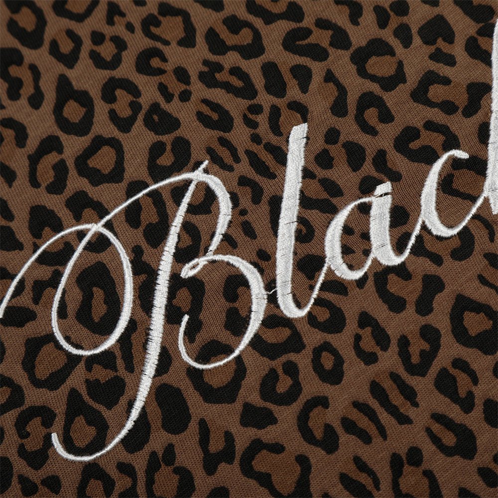 Leopard-print short-sleeve polo shirt in brown and black with white embroidered script logo.