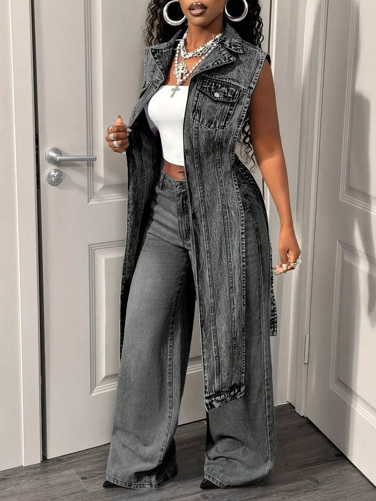 Open-front high-low denim vest with vintage wash and chest pockets, worn over a white crop top — Trendsi