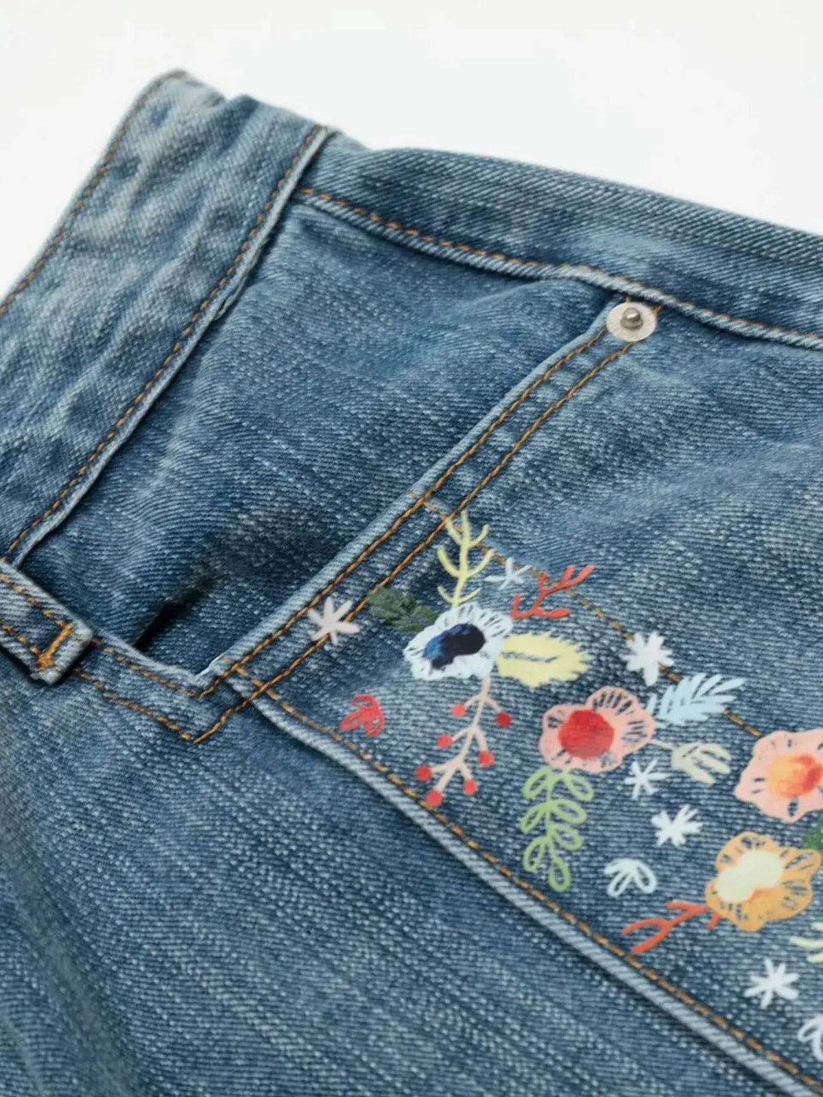 Men's denim shorts with colorful floral embroidery along the front pocket and trim, blue wash, by Trendsi