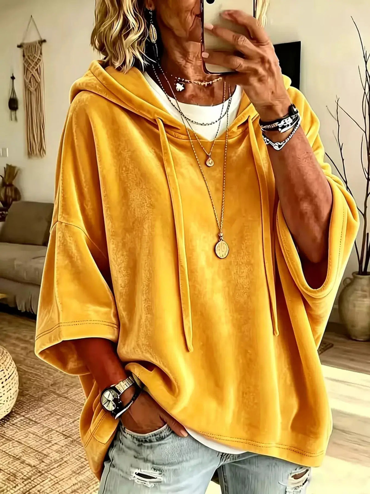 Velvet loose-fit hoodie with drawstring in mustard yellow, worn over a white tee.