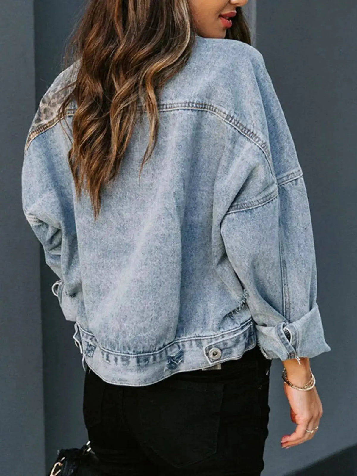Leopard print distressed denim jacket with button front, back view in light wash