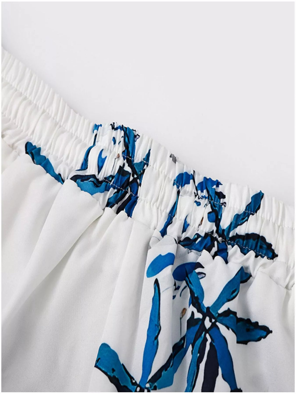 Men's plus-size tropical print shorts set by Trendsi; white fabric with blue abstract print, elastic waistband.