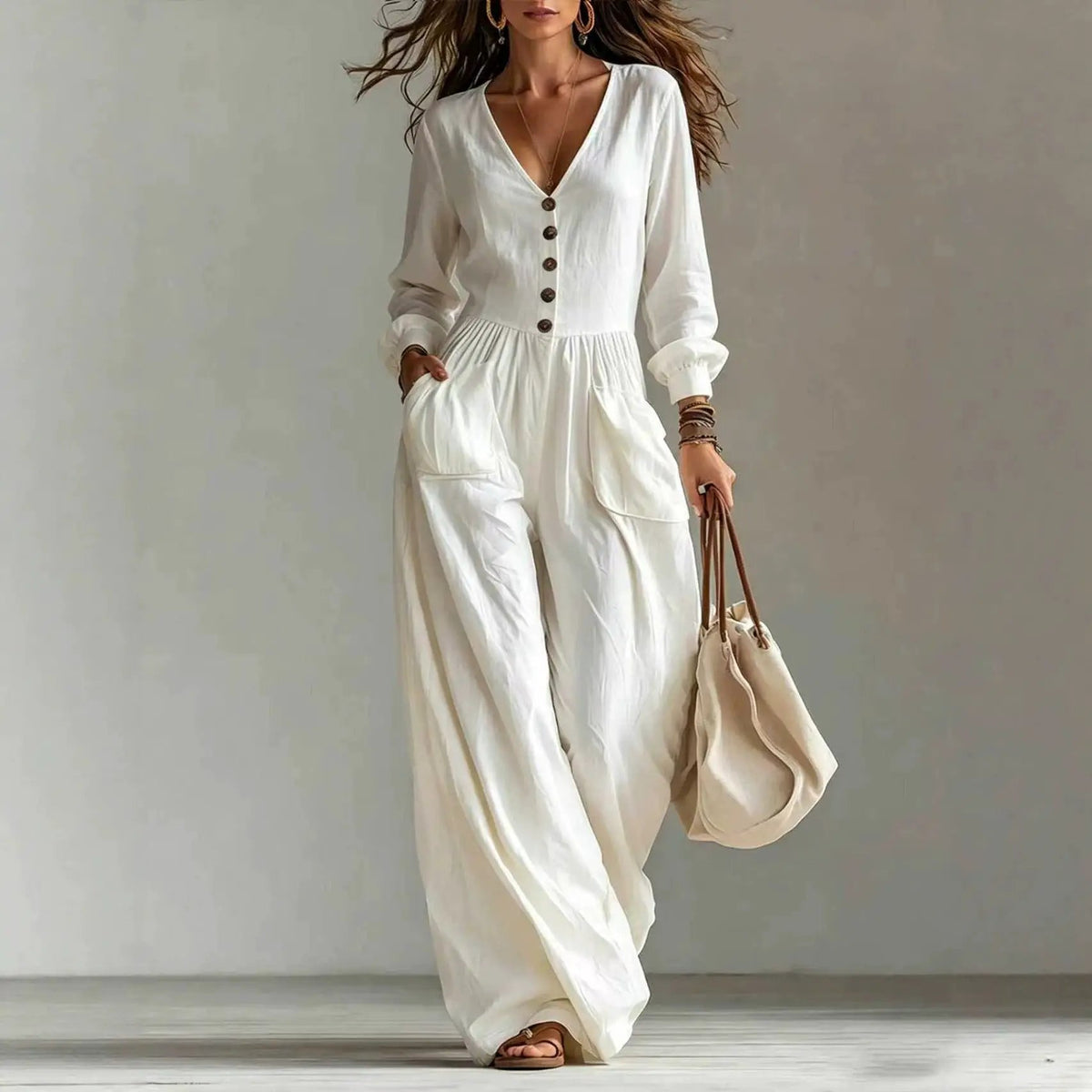 White jumpsuit with V-neck, long sleeves, button-down front and side pockets.