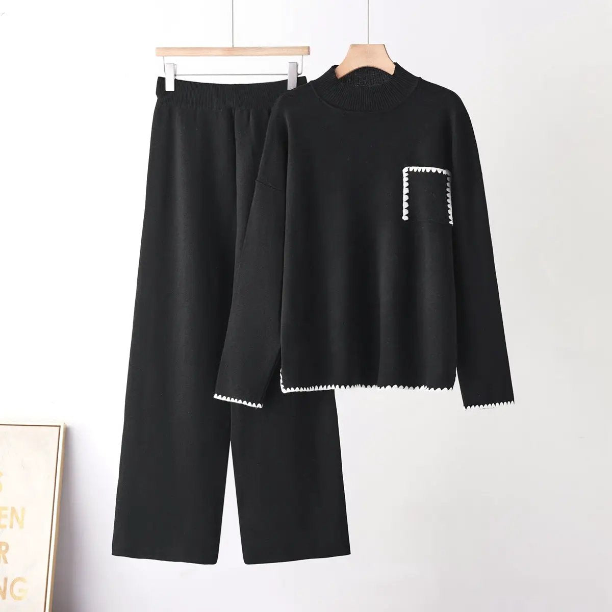 Two piece knit set by eprolo in black; half high-neck top with white-stitch pocket, paired with straight-leg pants.