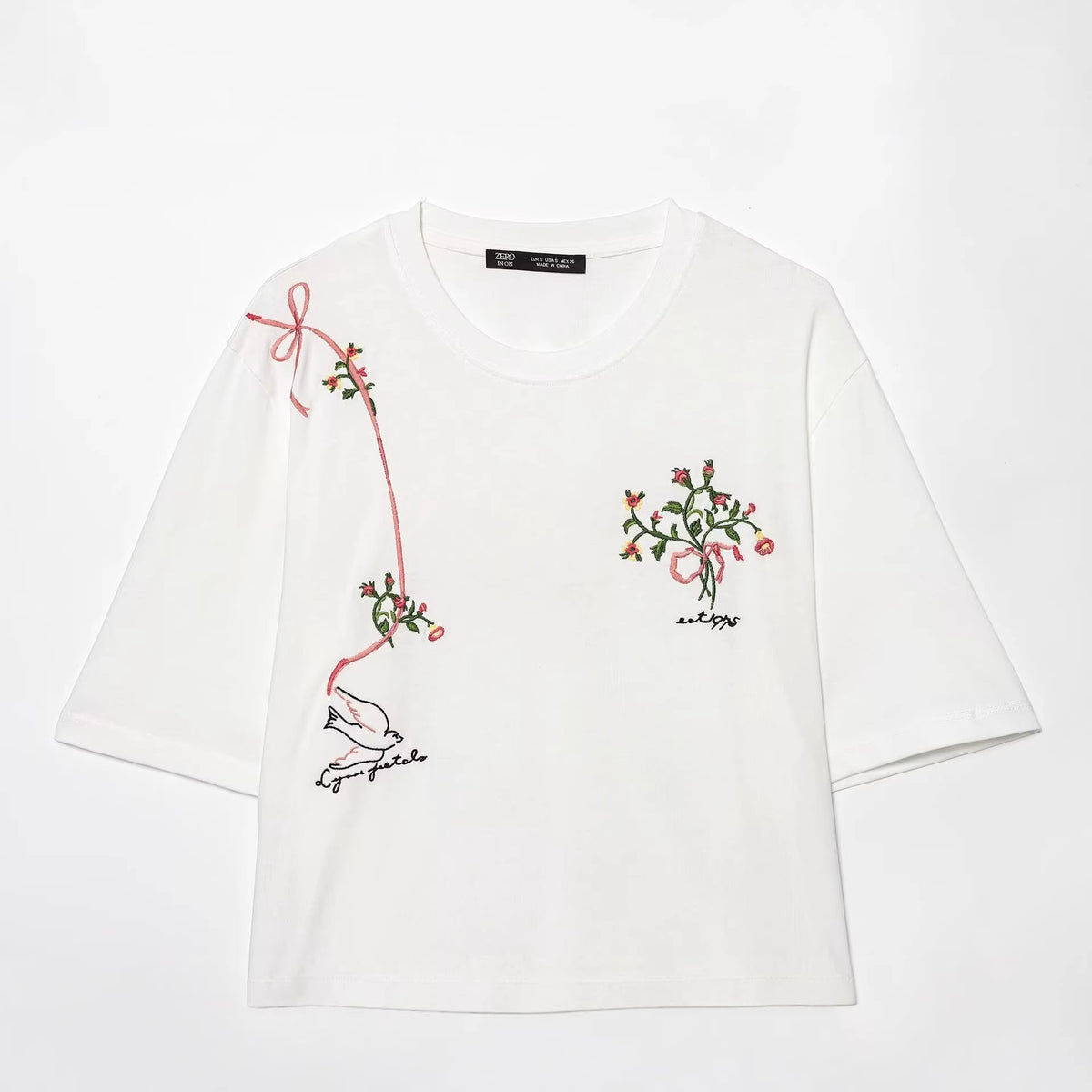White T-shirt with pink and green floral embroidery on the front, three-quarter sleeves