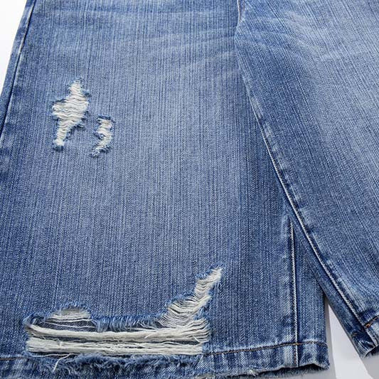 Denim shorts in blue with distressed rips and frayed hem