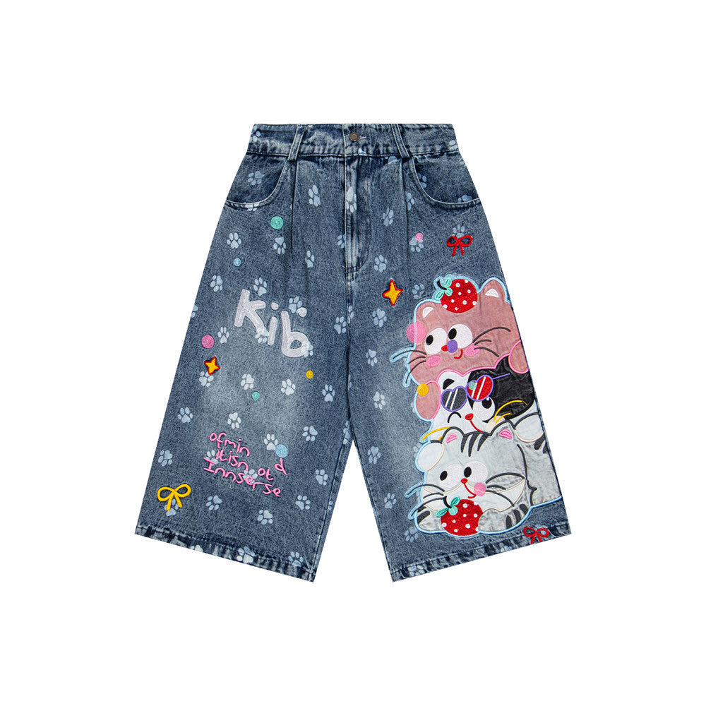 Cat cartoon denim shorts, blue denim with paw-print pattern and a large cat graphic on one leg, street fashion.