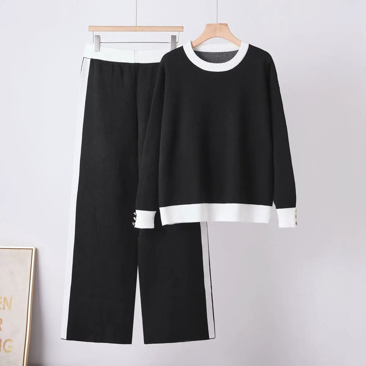 Women cozy two-piece knit set: black sweater with white collar and cuffs, black wide-leg pants with white side panels