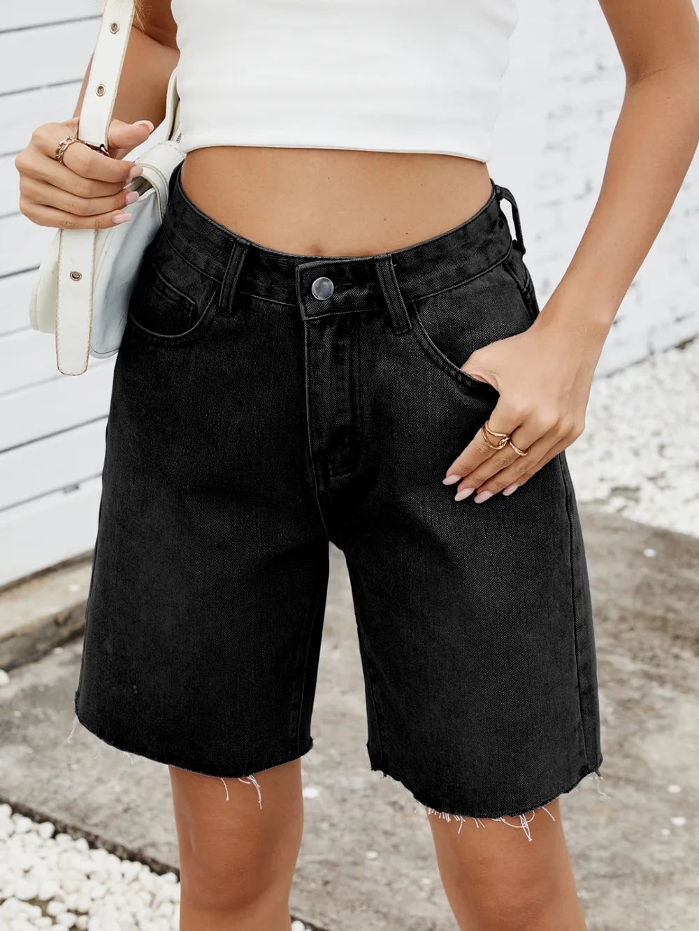 Washed black denim shorts with frayed raw hems, mid-thigh length