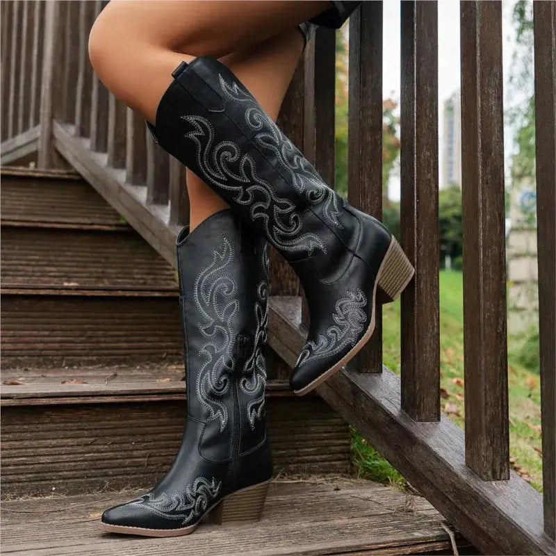 Women’s retro western embroidered cowboy boots in black with silver stitching and a stacked heel.