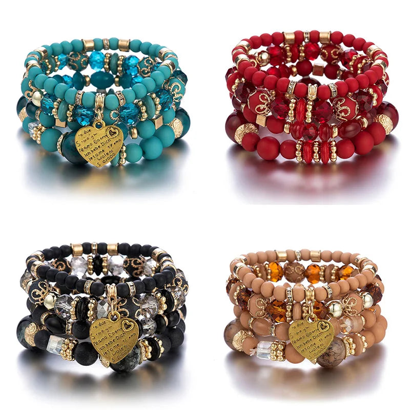 Bracelet set: four boho crystal heart stackable elastic bracelets in teal, red, black, and nude with gold heart charms.