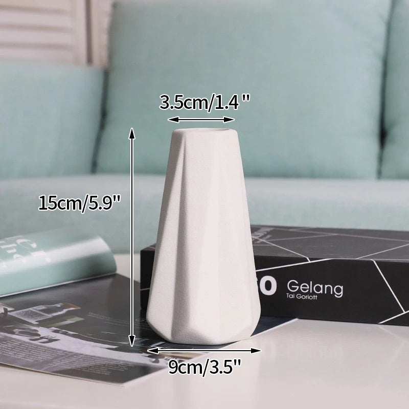 Ceramic vase, white with geometric facets, 15 cm tall, 9 cm base, 3.5 cm opening; desktop decorative piece.
