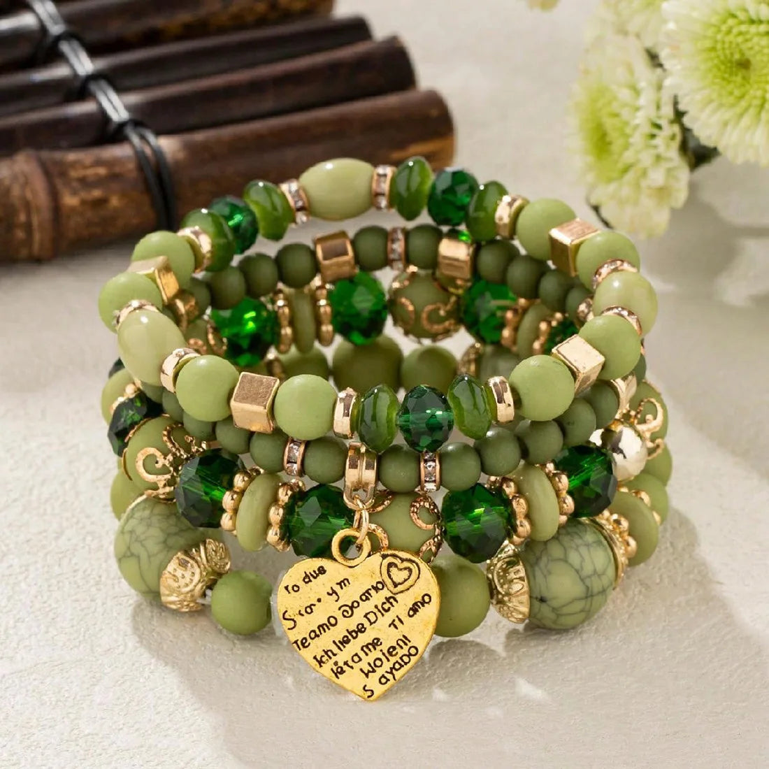 Boho crystal heart bracelet set, stackable green beaded elastic bracelets with gold spacers and a heart charm.