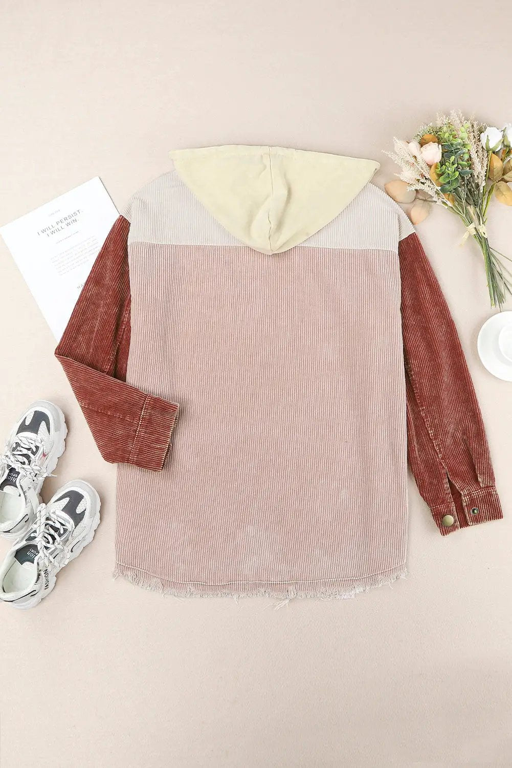 Snap-front hooded corduroy shacket with dusty pink body, rust sleeves, and cream hood, frayed hem.