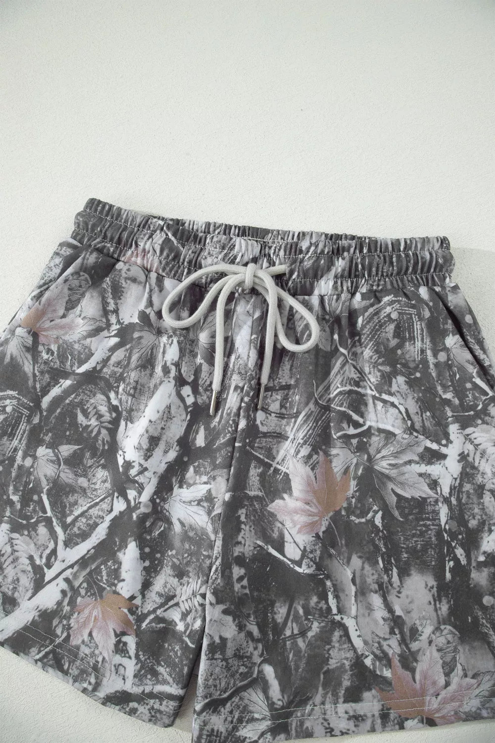 Abstract Maple Leaf Printed Tie Elastic Waist Shorts by Trendsi; gray/black pattern with drawstring waist.