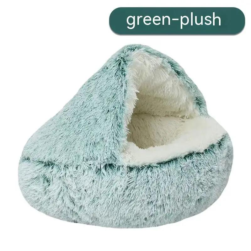 Cat bed in green plush with cream interior, semi-closed nest design.