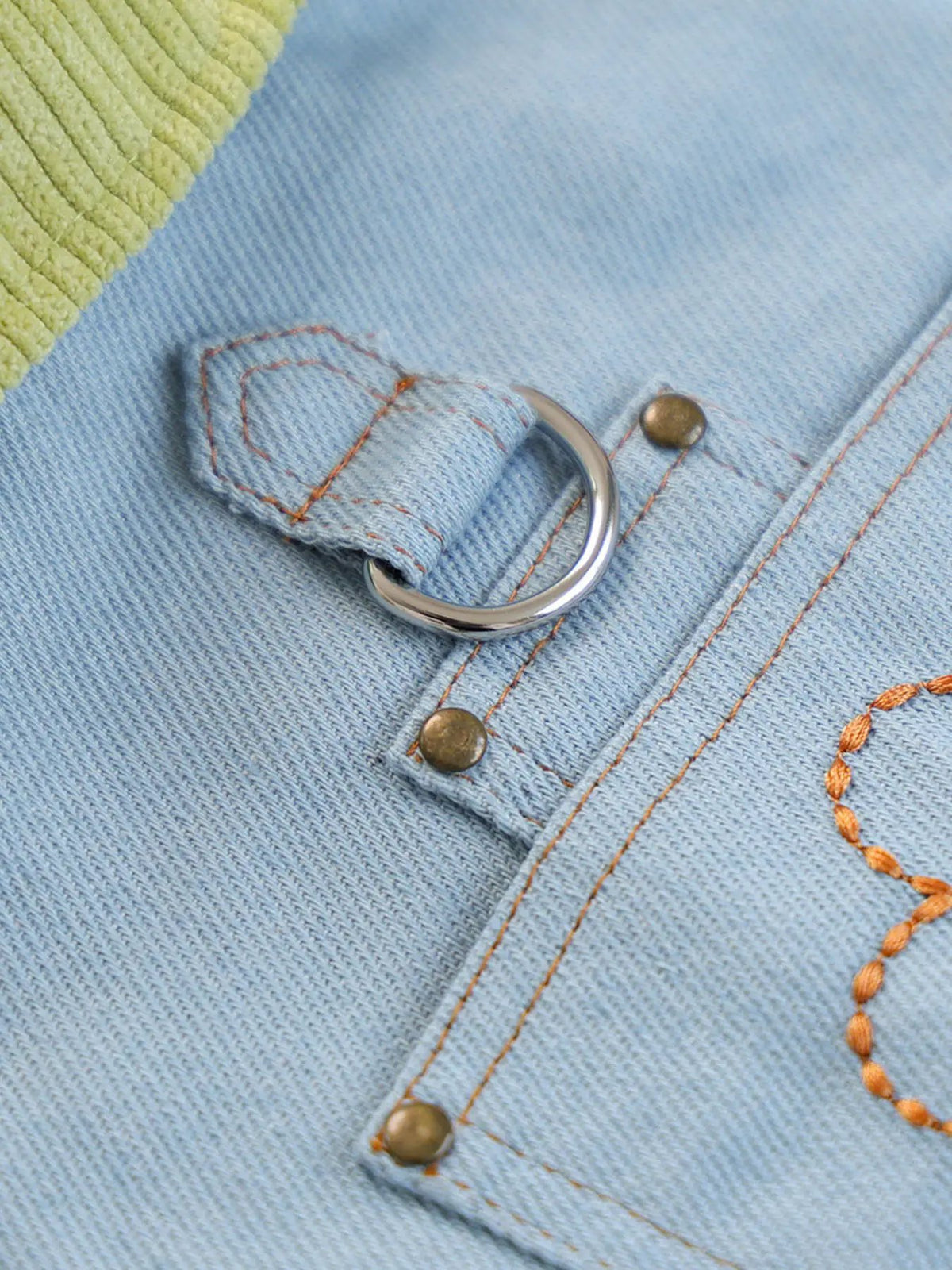 Denim pet top by Trendsi; close-up of light blue denim with a metal D-ring, orange stitching, and lime strap.