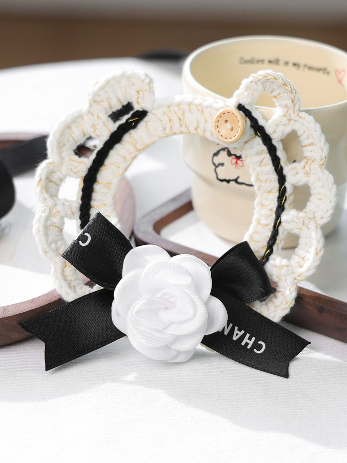 Contrast Pet Scarf in white knit with black stripe, wooden button, Chanel ribbon bow, and white fabric flower.