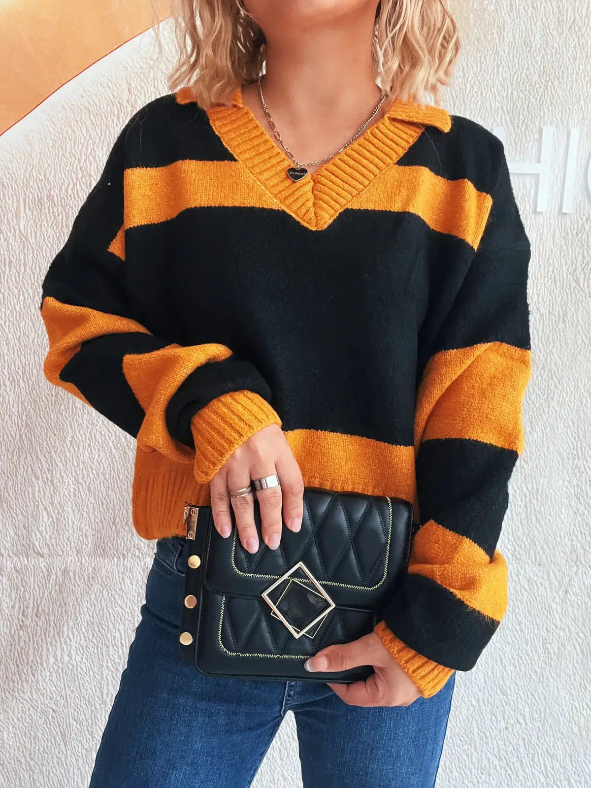 Color-block long sleeve sweater in black and orange with a ribbed V-neck and soft stretch polyester blend.