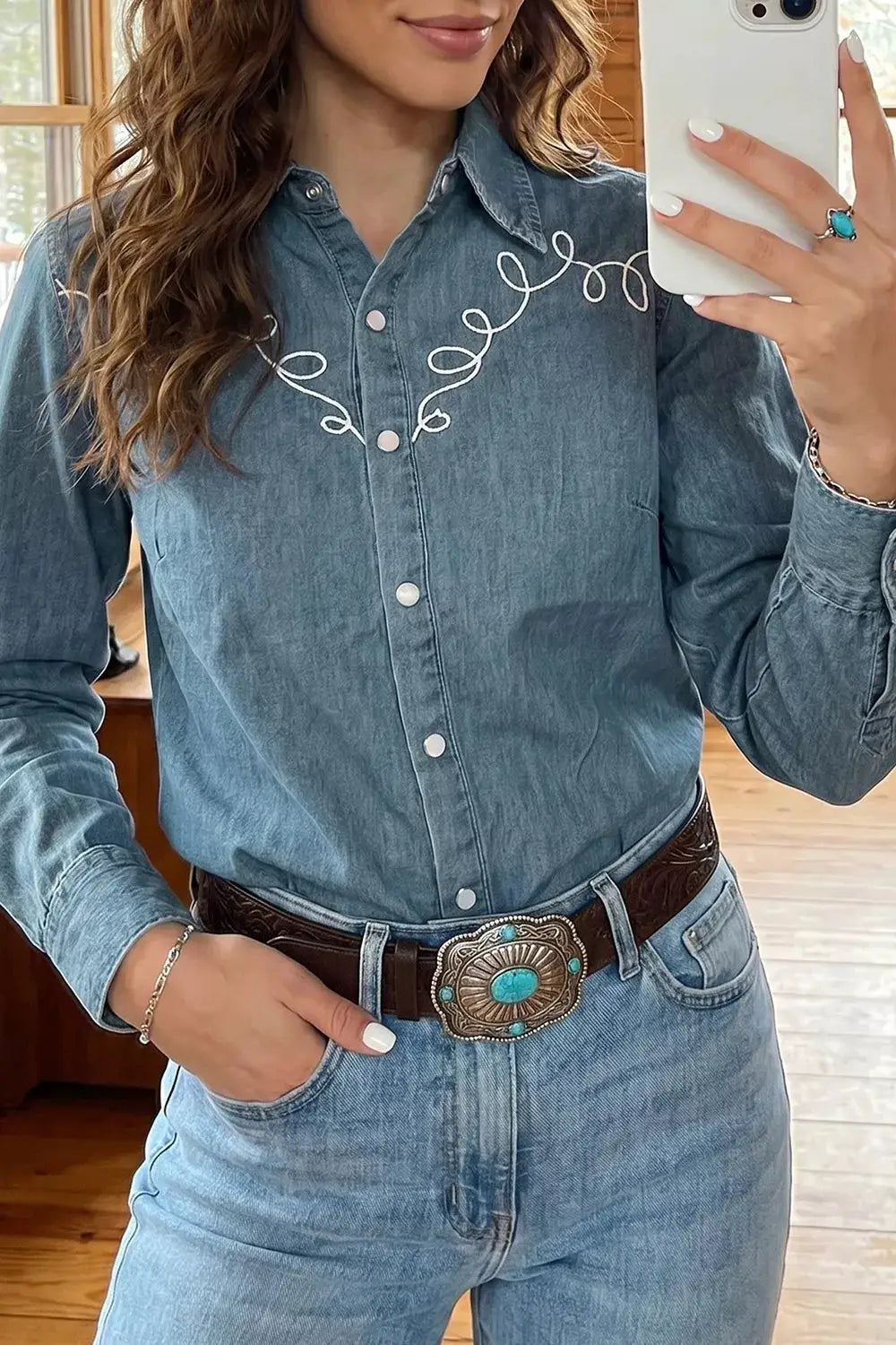 Embroidered Western denim top in blue with white looping embroidery and snap buttons
