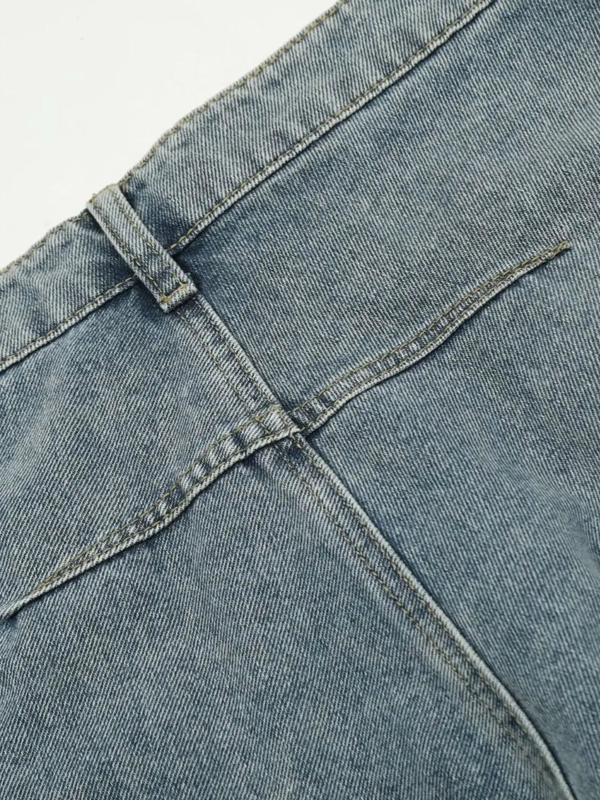 Men's denim shorts; washed blue fabric with breathable stretch, close-up of belt loop and pocket seam.