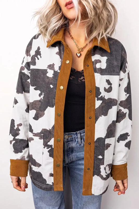 Multi-color cow print western denim jacket with tan corduroy collar, button-up front, brass snaps, and front pockets