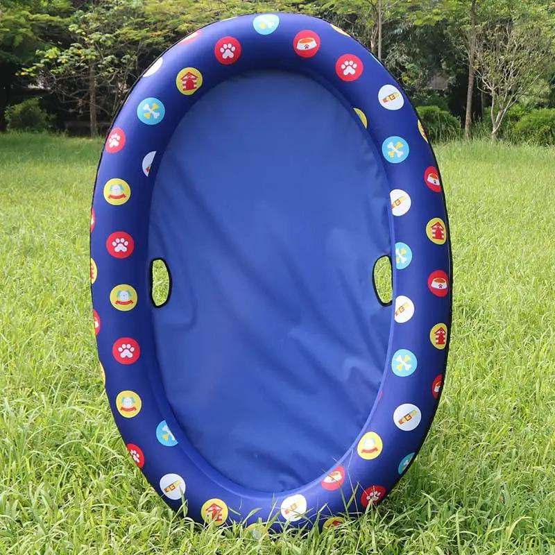 Dog pool inflatable hammock float, blue ring with colorful circular decals, on grass.