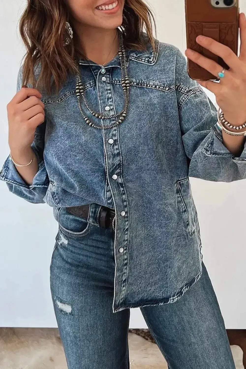 Western long sleeve denim jacket with button-front placket and pockets in blue denim