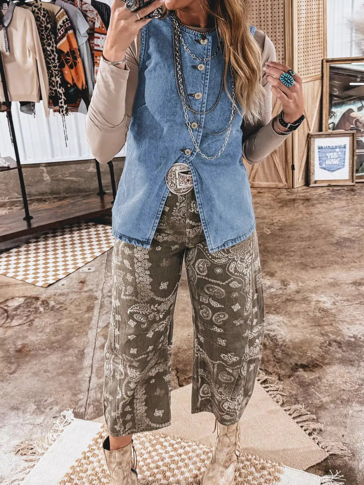 Slim-fit blue denim vest with button-front, layered over a beige long-sleeve top