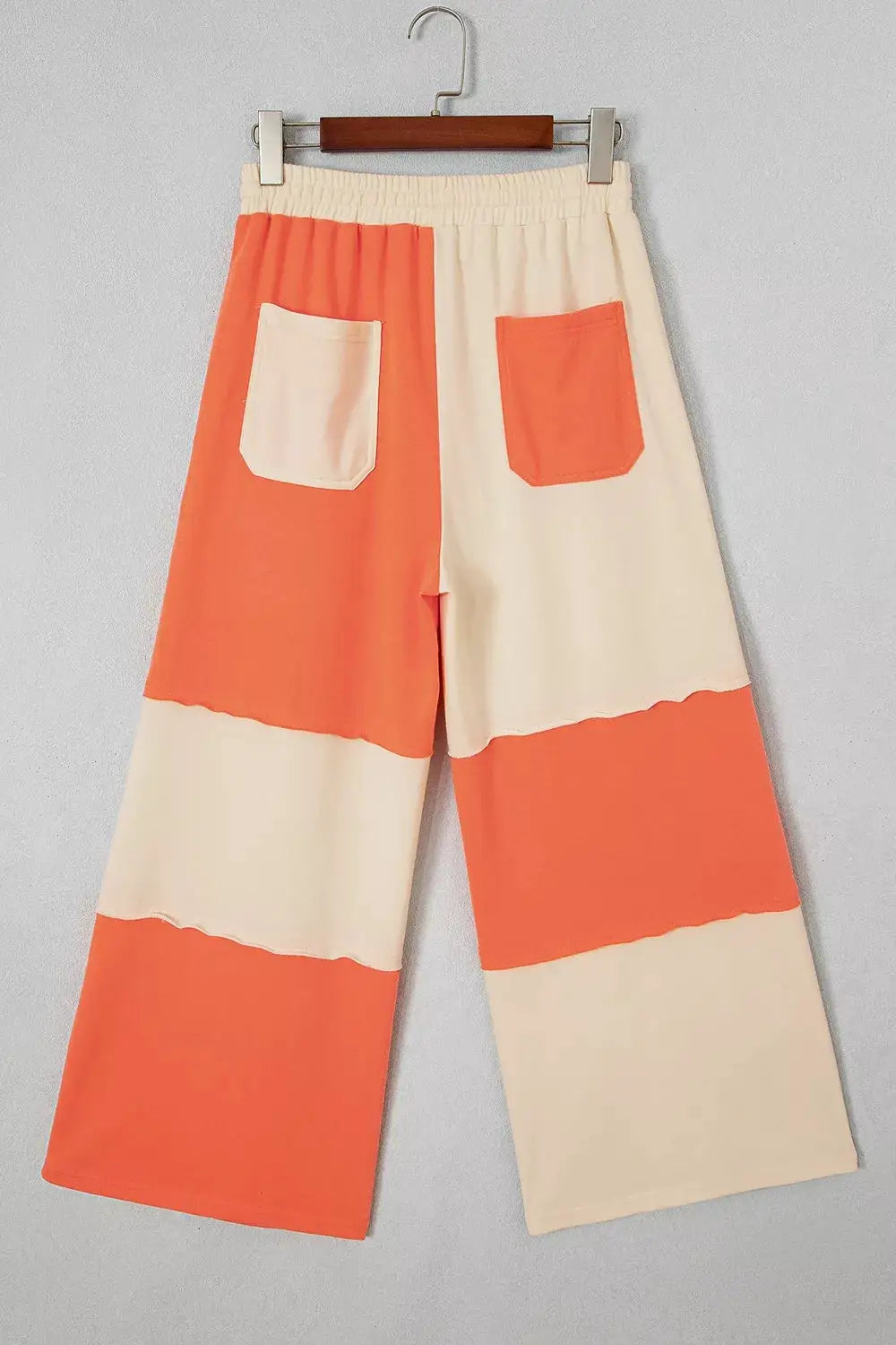 Raw seam colorblock wide-leg ankle-length pants in cream and coral with patch pockets