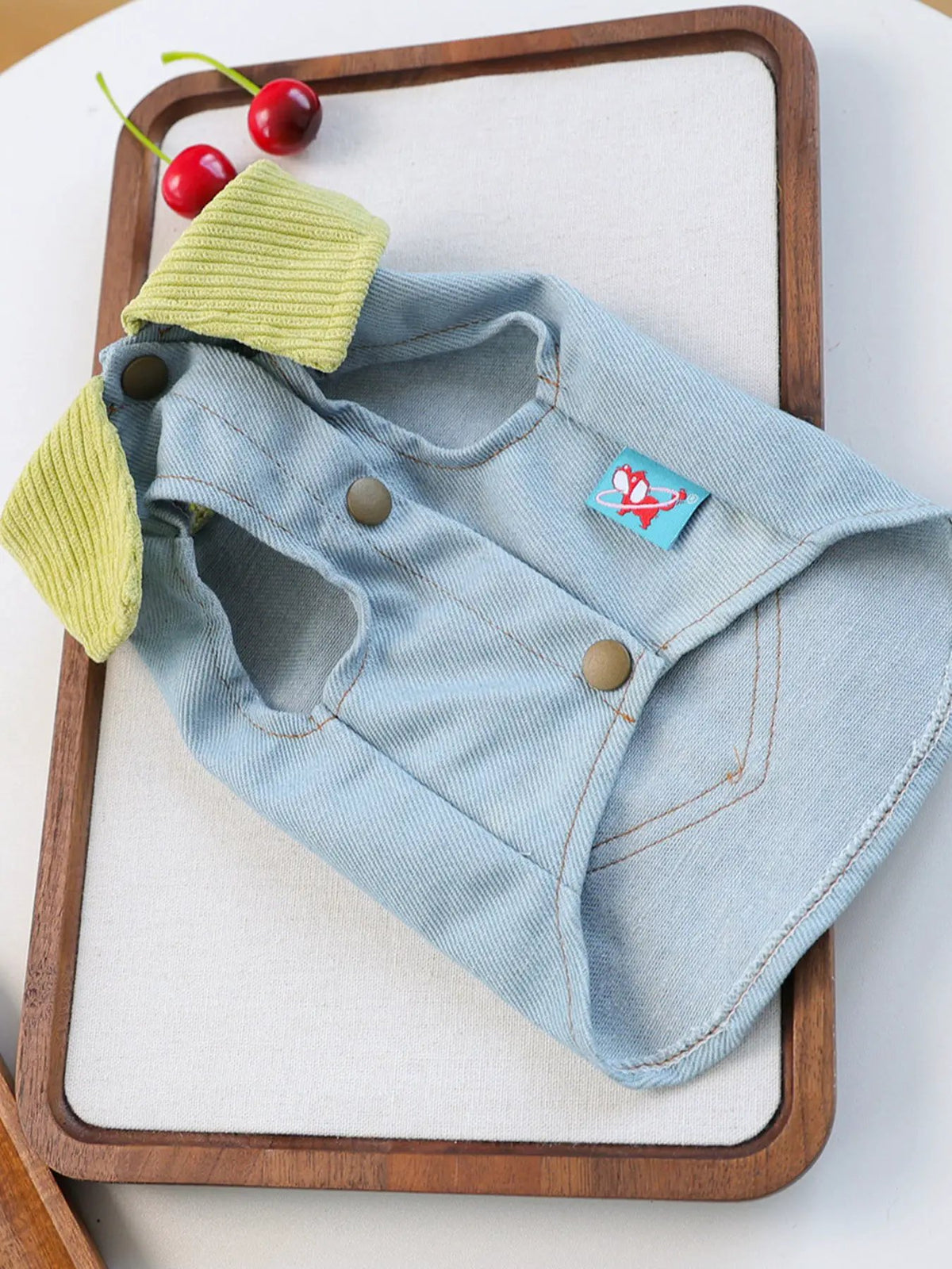 Denim pet top with lime green ribbed collar, light blue fabric, snap closures, turquoise brand tag