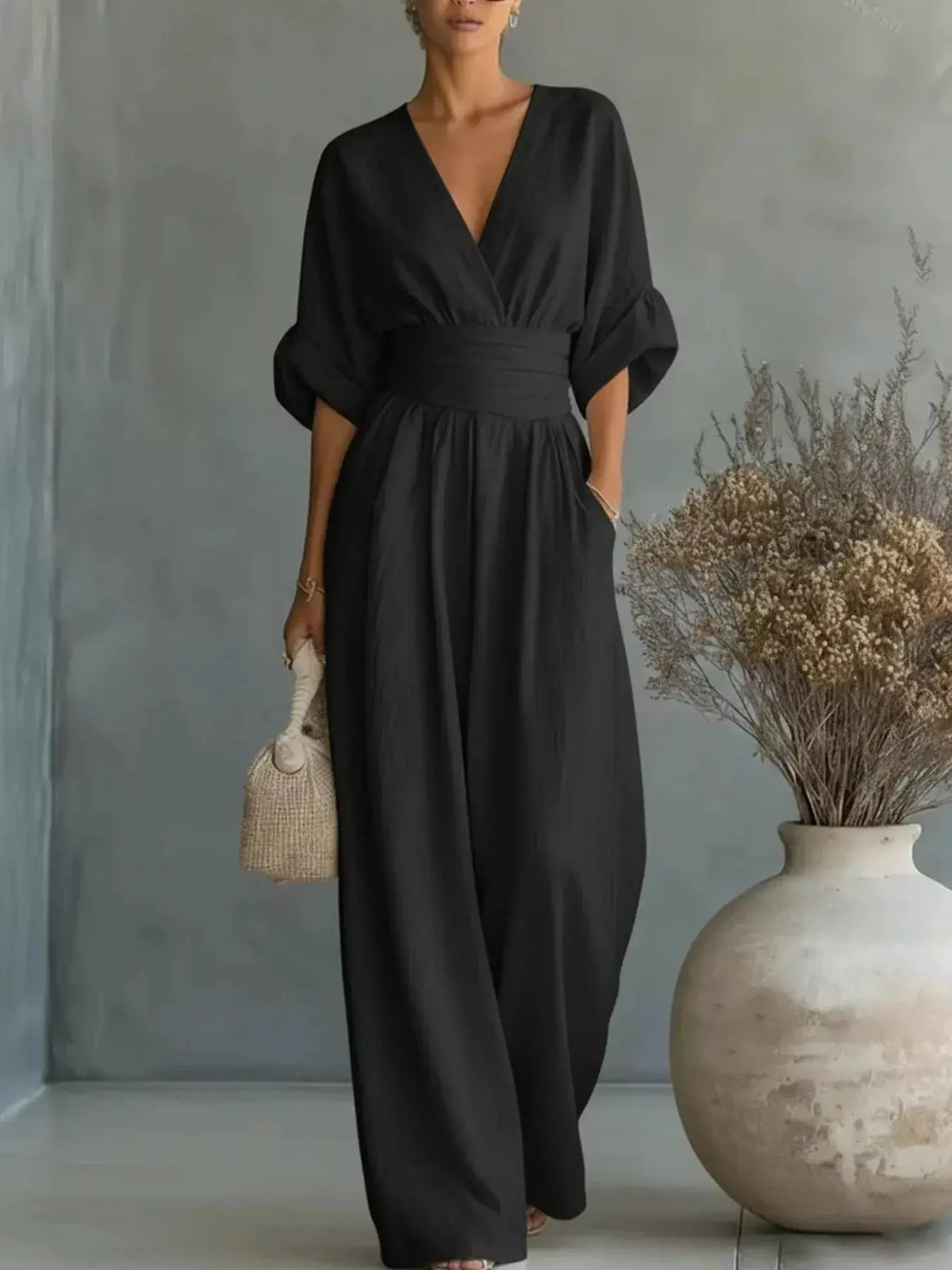 Full-size black jumpsuit by Trendsi with V-neck wrap bodice, billowy half sleeves, and wide-leg pants