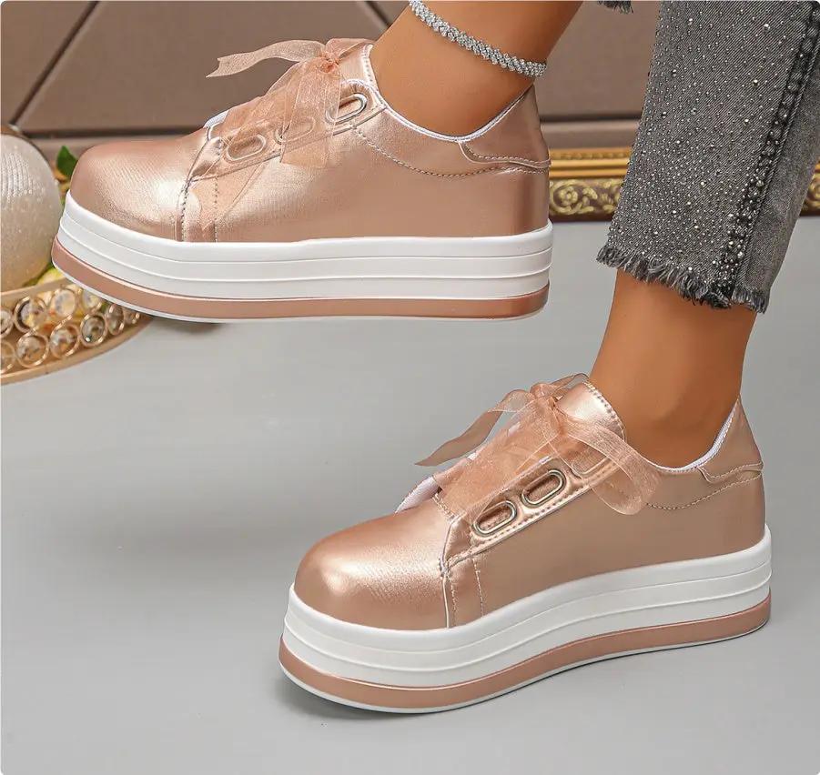 Pair of women's rose gold metallic platform lace-up flats with round toe and white-tan sole