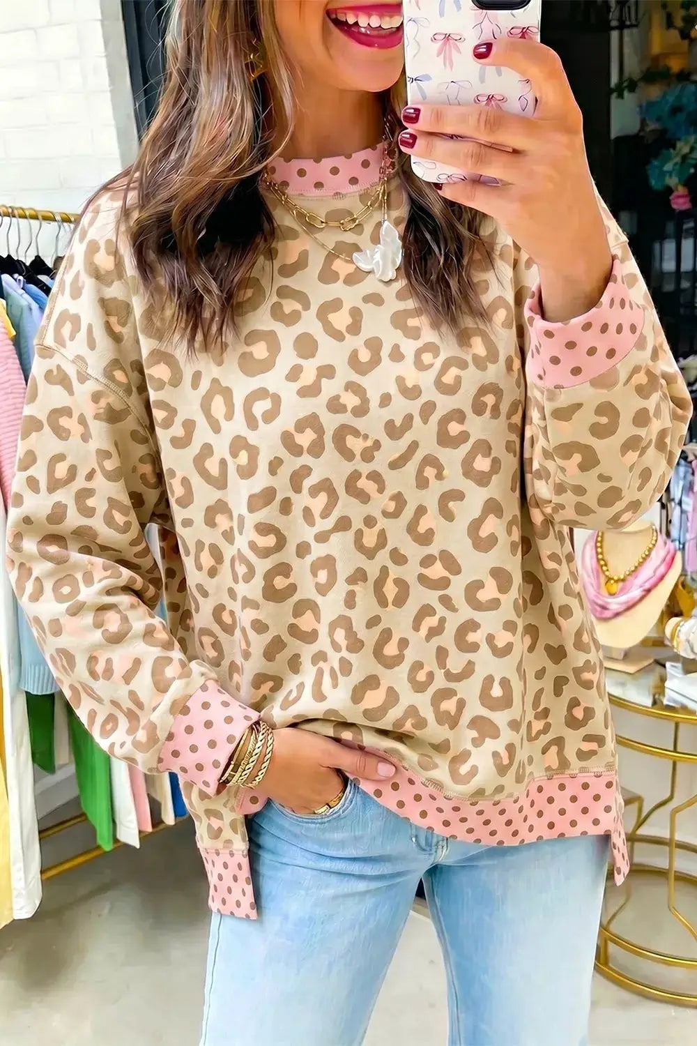 Leopard print sweatshirt with pink polka dot cuffs and hem, oversized fit.