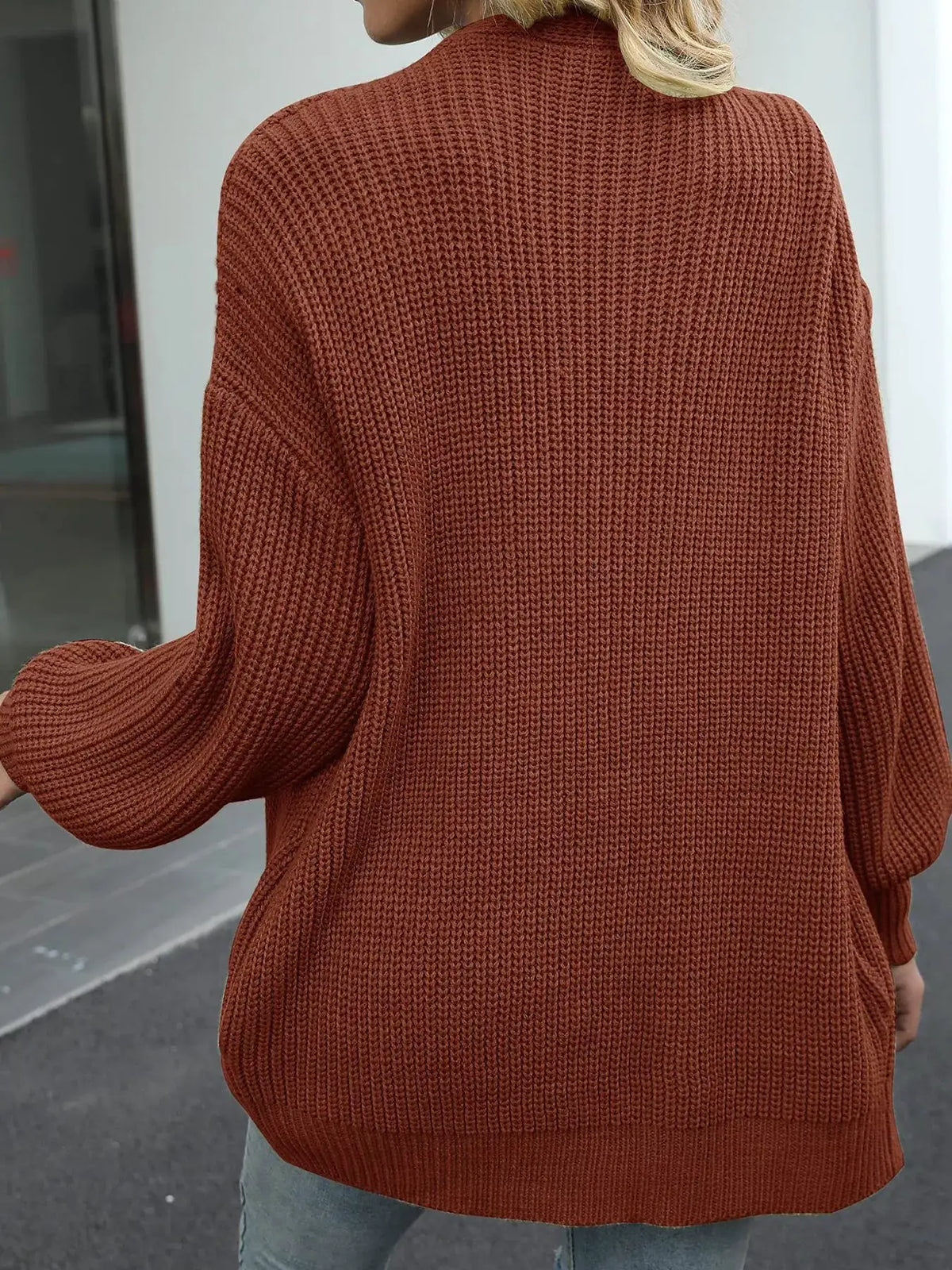 Cozy oversized chunky knit cardigan in rust color with lantern sleeves, open front.