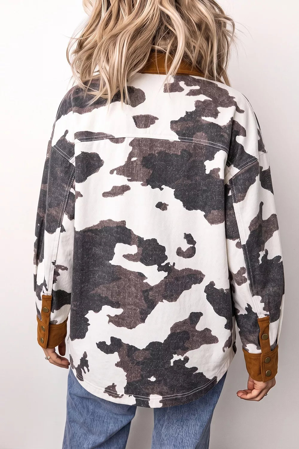 Long-sleeve denim jacket with multicolor cow-print and brown cuff accents