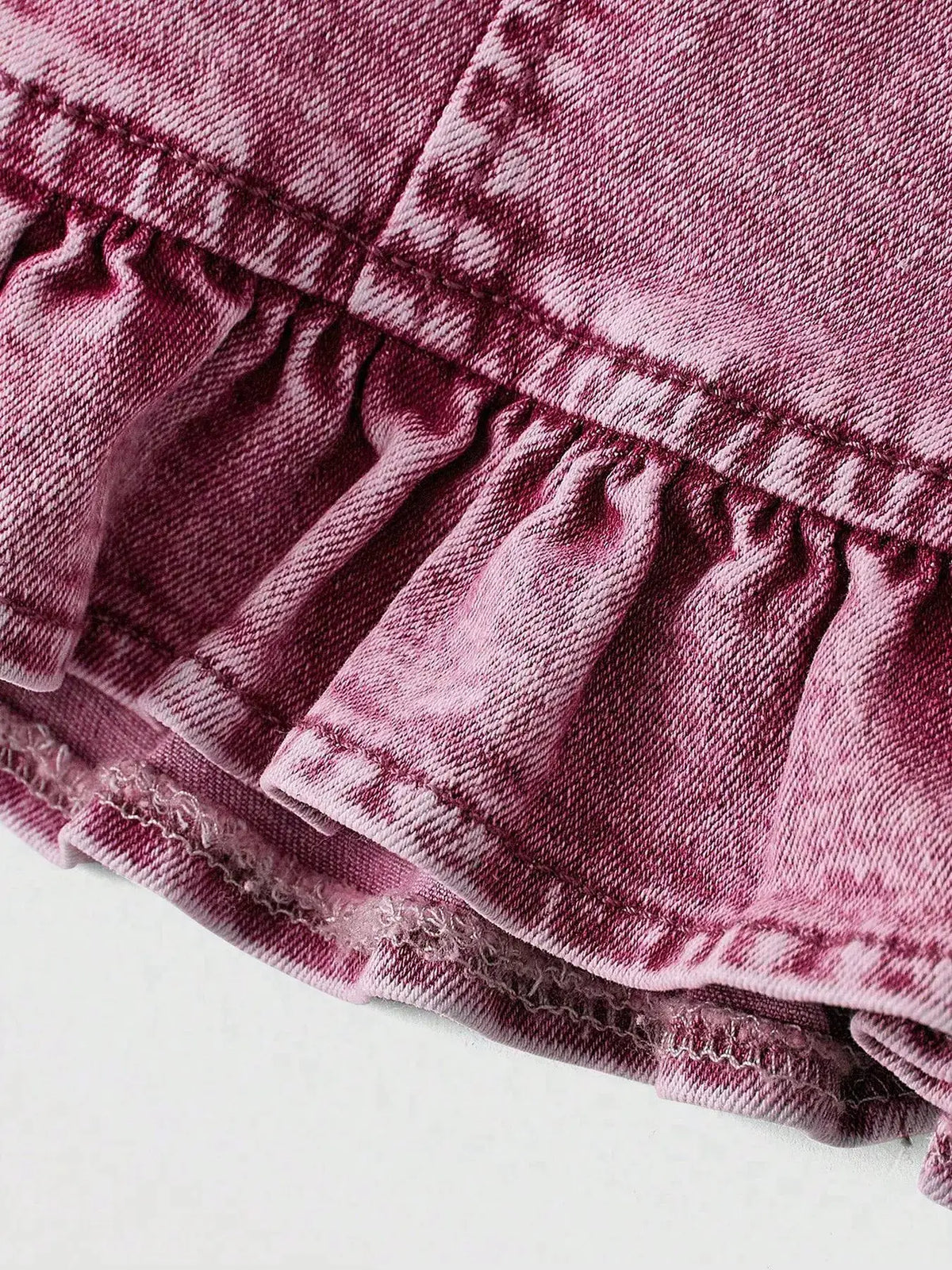Pink denim cami top fabric close-up with stitched seams