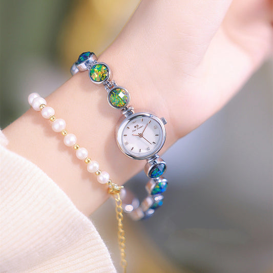 Fashion Peacock Temperament Women's Watch with silver-tone case and iridescent green-blue links, paired with a pearl bracelet
