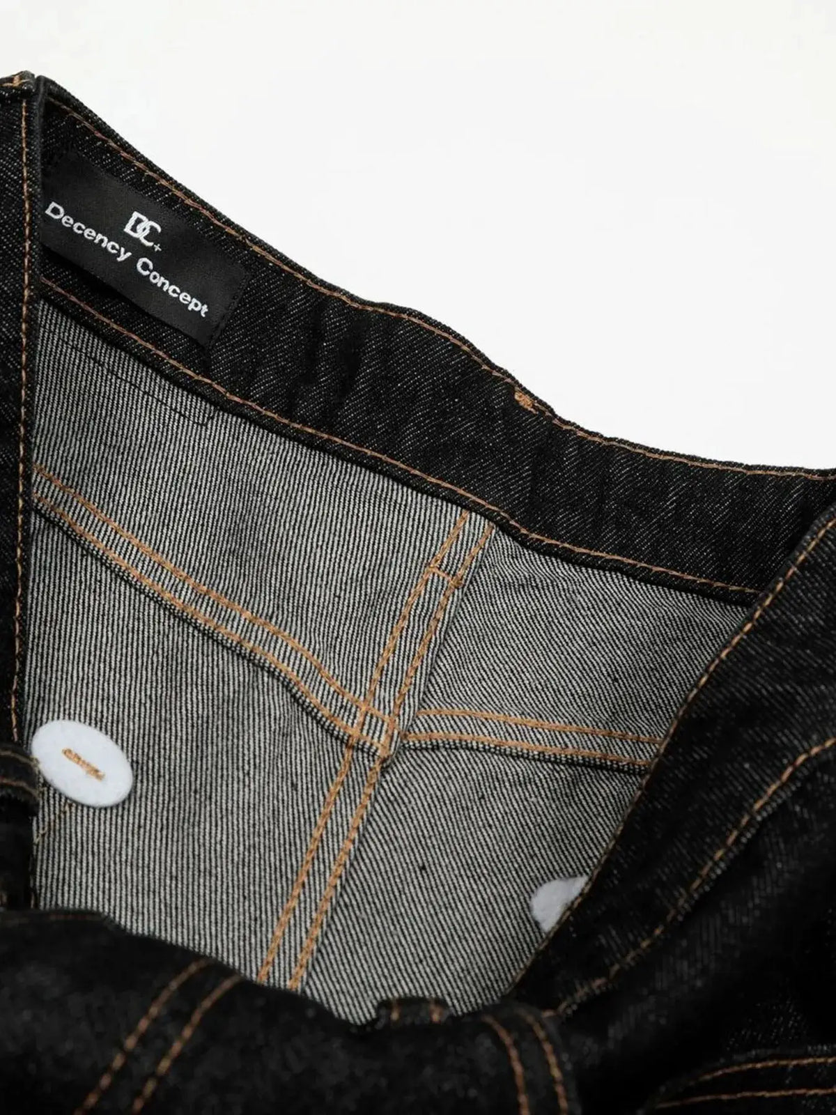 Men's relaxed baggy denim shorts in dark wash with orange stitching; Decency Concept label visible.