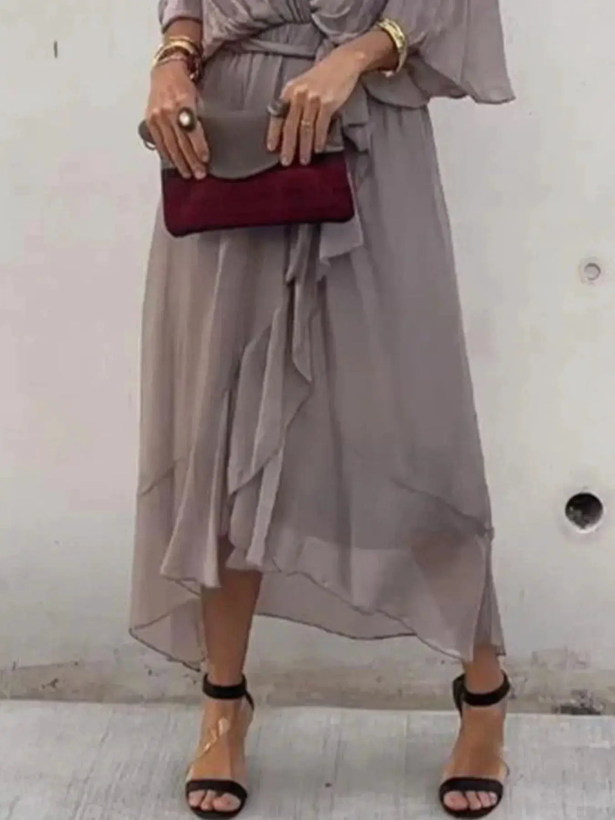 Plus-size flowy tie-front midi dress in gray with flutter sleeves, paired with burgundy clutch