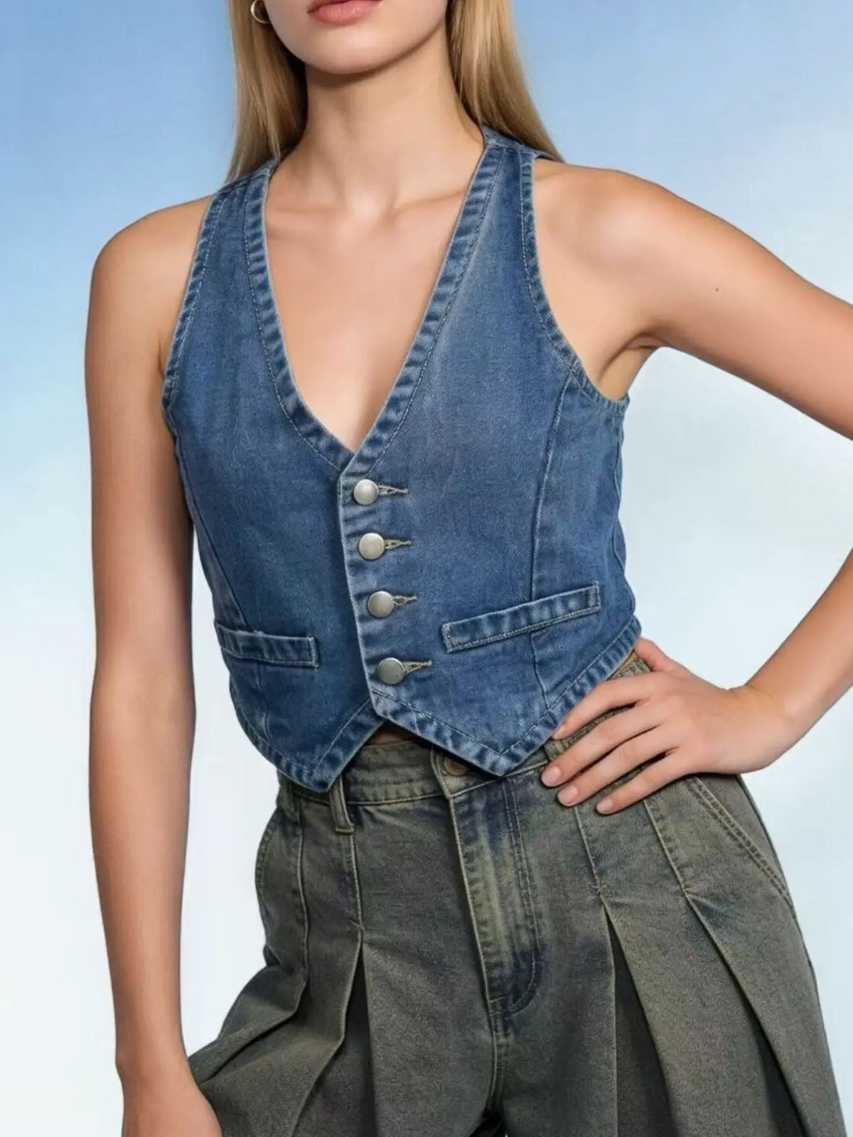 Classic Button Down Denim Vest in blue cotton blend; front silver button placket, cropped hem, two small pockets