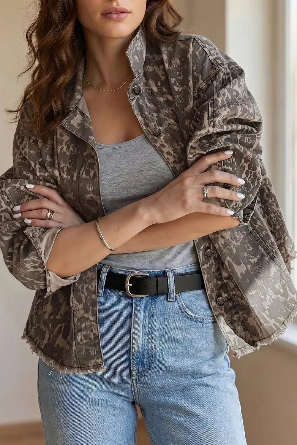 Denim jacket with gray abstract print, long sleeves, raw-hem detail.