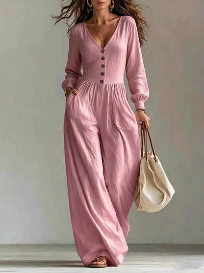 Women's pink V-neck jumpsuit with long sleeves, button front and pockets, wide-leg pants.