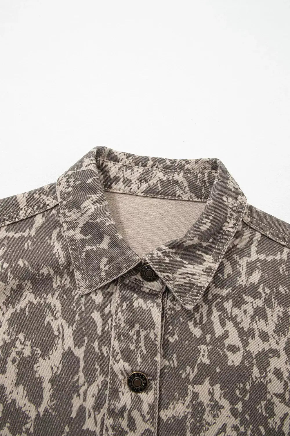 Abstract print denim jacket with gray-beige camo pattern, long sleeves, button-front.
