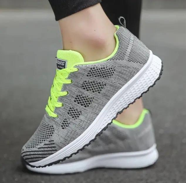 Women’s sports sneakers by AdTec, grey knit mesh upper with neon lime laces and white midsole, black outsole (pair)
